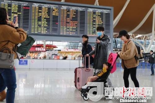 旅客帶著孩子前往辦票柜臺(tái)辦理登機(jī)手續(xù)?！∫罅⑶?攝