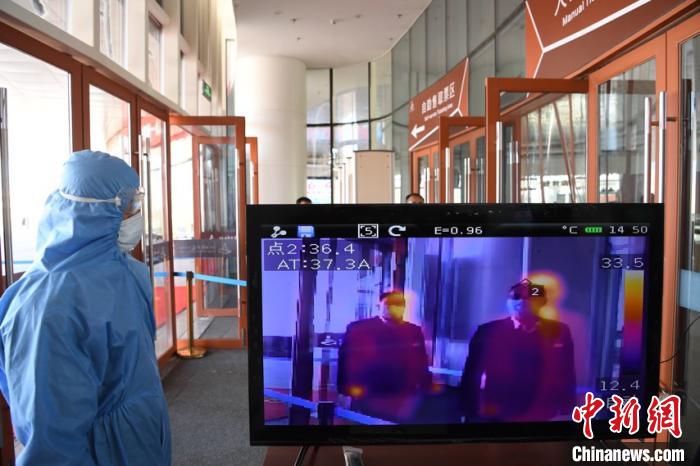圖為游客步行通過(guò)紅外線測(cè)溫通道?！钇G敏 攝