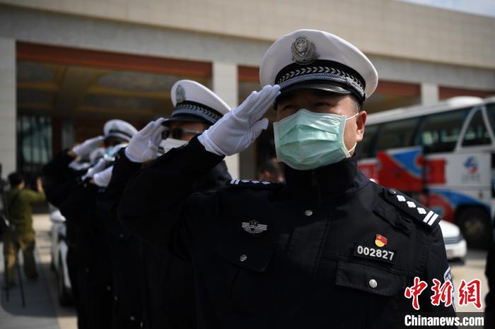 圖為交警們向醫(yī)療隊敬禮?！】灯?攝