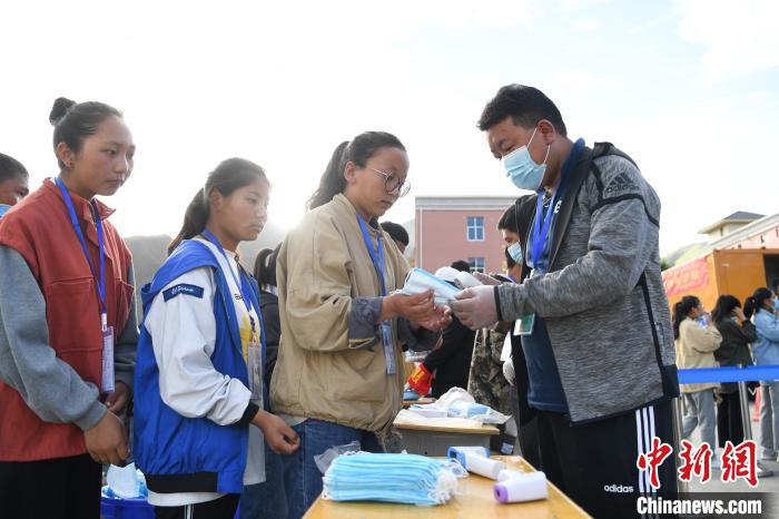 7月7日，考生在拉薩三高考點(diǎn)外領(lǐng)取口罩。　何蓬磊 攝