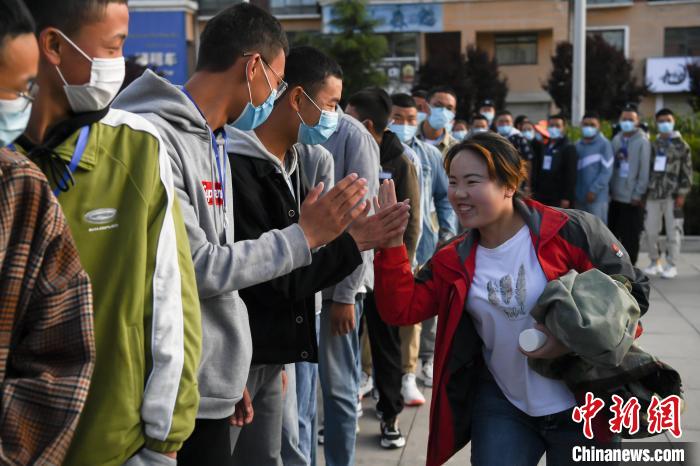 7月7日，拉薩三高考點(diǎn)外，領(lǐng)隊(duì)老師與考生擊掌鼓勁加油?！『闻罾?攝