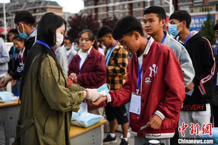 7月7日，考生在拉薩三高考點(diǎn)外測(cè)量體溫?！『闻罾?攝