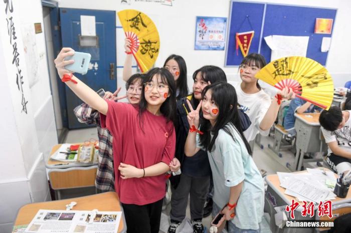 資料圖：6月6日，2021年高考前夕，湖南長(zhǎng)沙同升湖實(shí)驗(yàn)學(xué)校高三年級(jí)，考生們?cè)诮淌覂?nèi)合影。 楊華峰 攝